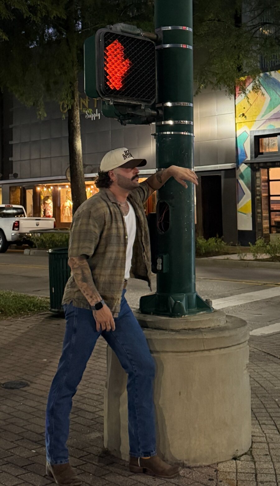 Tyler Evyns standing at a downtown street corner at night
